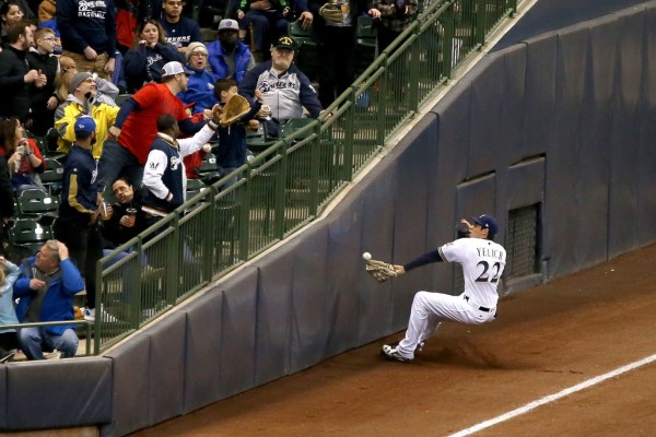 Christian Yelich sliding into the bottom frame of the Miller Park outfield (Getty Images)